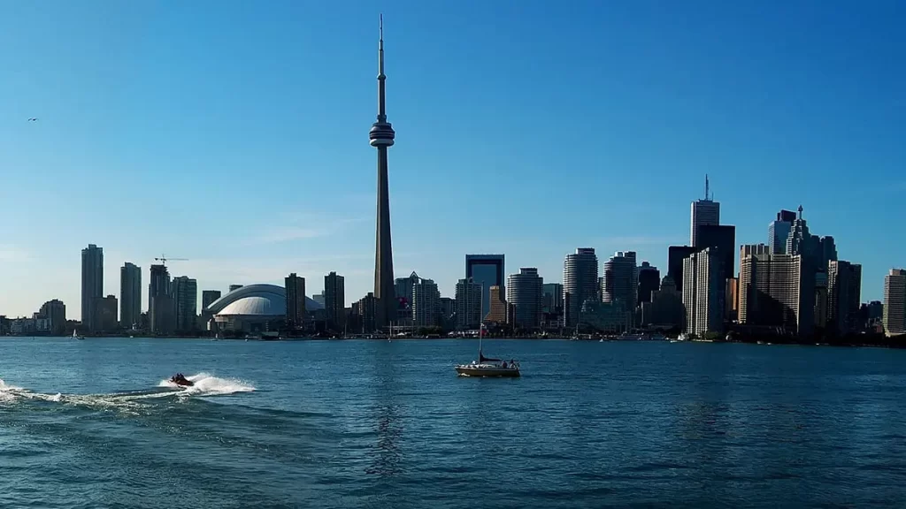 Person riding a jet ski from JetSkiGTA on Lake Ontario, with the Toronto skyline in the background.