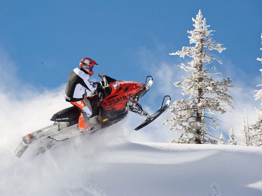 Guided snowmobile rental riding through forest trails in Ontario