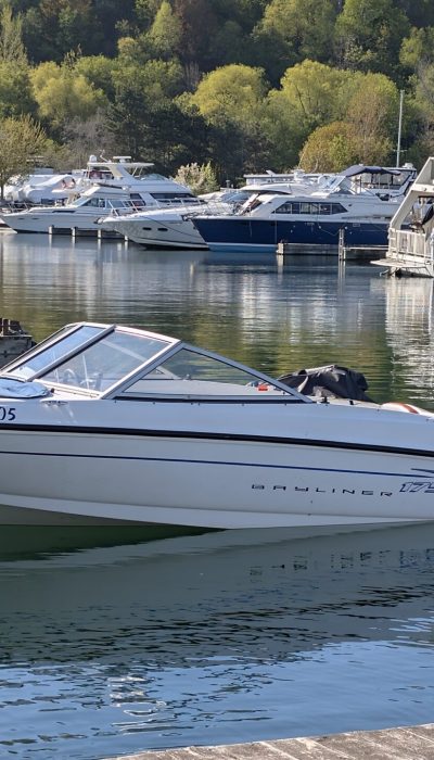 Two friends standing next to a Bayliner Bowrider boat rental at Bluffer’s Park Marina